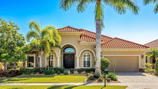 mediterranean / spanish-style home with a front yard and a garage