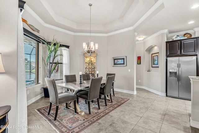 tiled dining area featuring an inviting chandelier, crown molding, and a tray ceiling