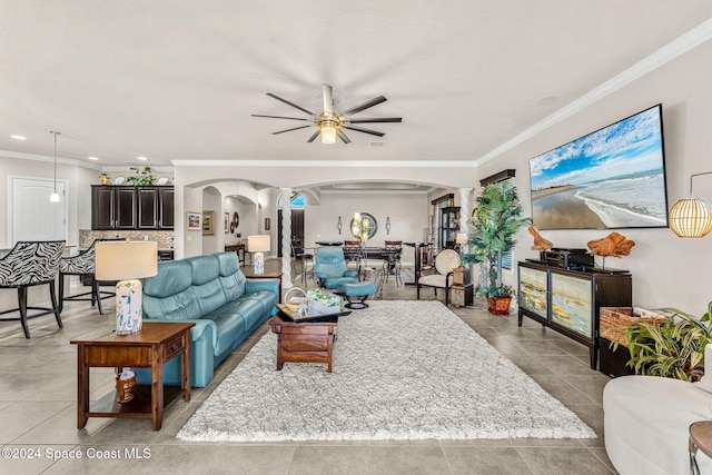 living room featuring crown molding, light tile patterned floors, and ceiling fan