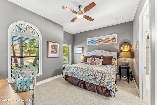 carpeted bedroom with ceiling fan and a textured ceiling