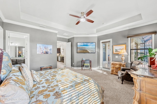 bedroom with light carpet, ceiling fan, a raised ceiling, connected bathroom, and ornamental molding