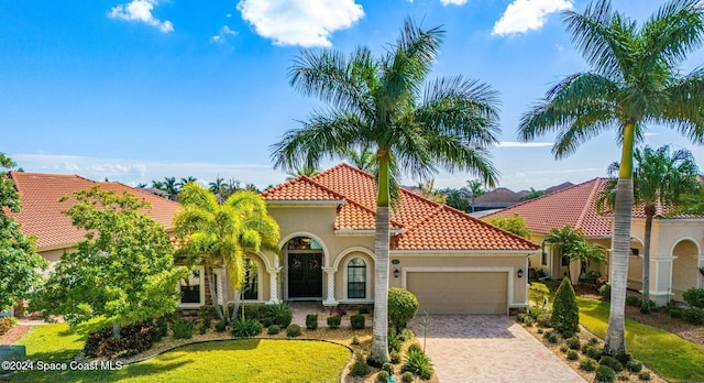 mediterranean / spanish home with a front lawn and a garage