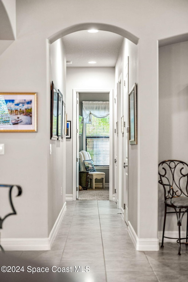 hallway with tile patterned flooring