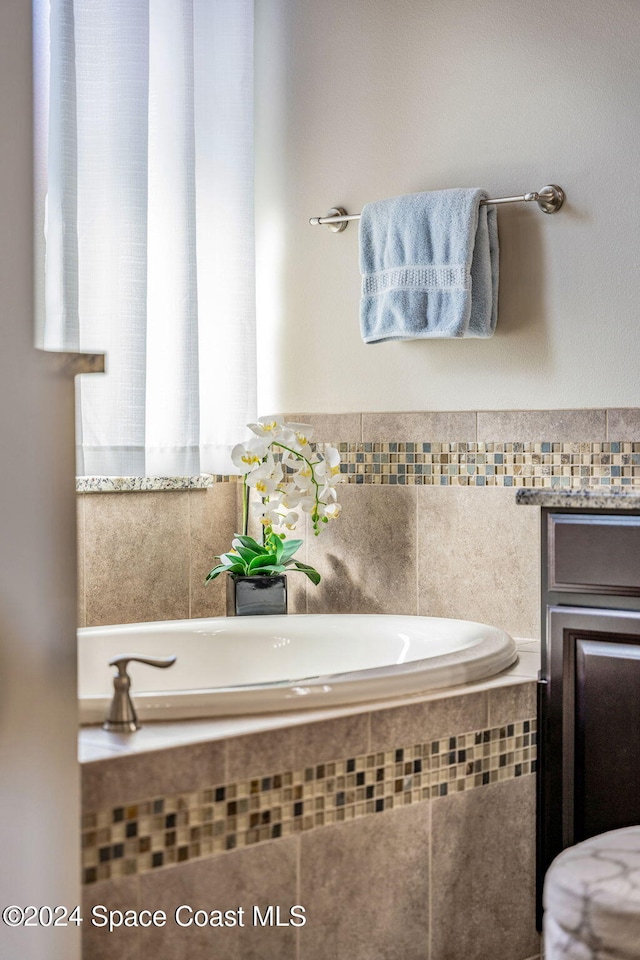 bathroom featuring a relaxing tiled tub