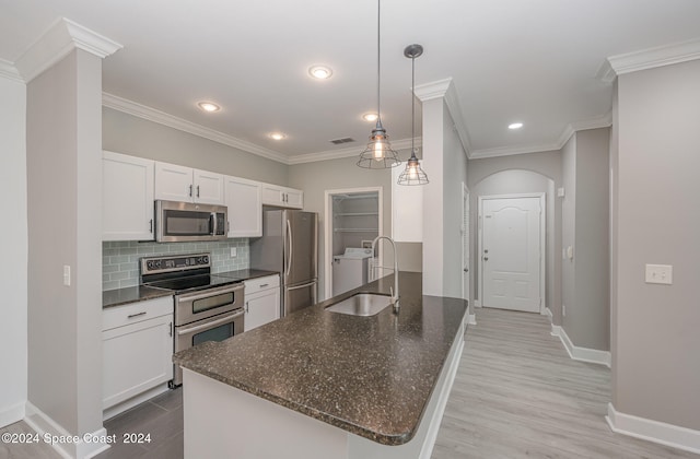 kitchen with pendant lighting, sink, white cabinetry, appliances with stainless steel finishes, and light wood-type flooring