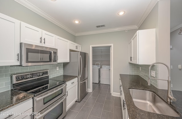 kitchen featuring sink, white cabinetry, stainless steel appliances, separate washer and dryer, and dark stone countertops