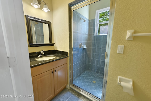 8053 S Indian River Dr, Ft Pierce, FL 34982 - bathroom with a textured wall, a shower stall, vanity, and tile patterned flooring