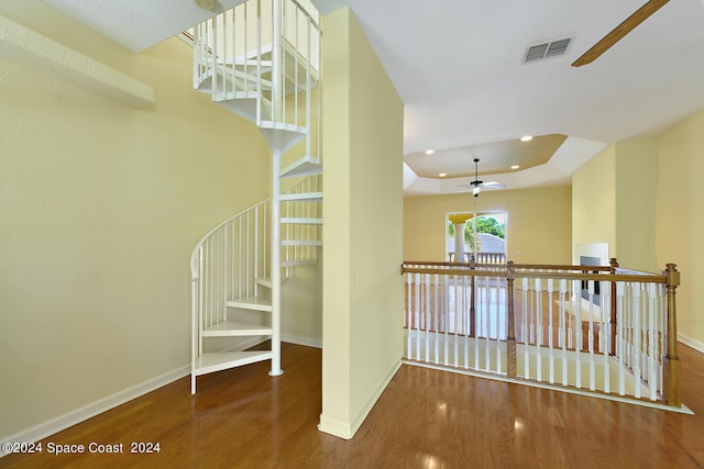 8053 S Indian River Dr, Ft Pierce, FL 34982 - stairway with ceiling fan, wood finished floors, baseboards, recessed lighting, and a raised ceiling
