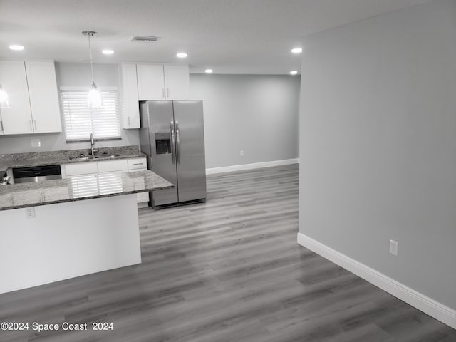 kitchen with white cabinets, hanging light fixtures, sink, appliances with stainless steel finishes, and dark stone countertops