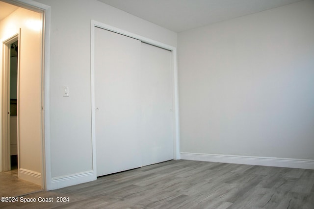 unfurnished bedroom with light hardwood / wood-style flooring and a closet