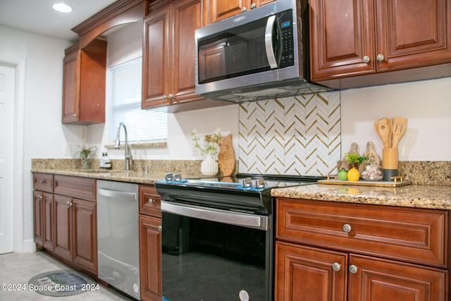 kitchen featuring appliances with stainless steel finishes, backsplash, sink, and light stone counters