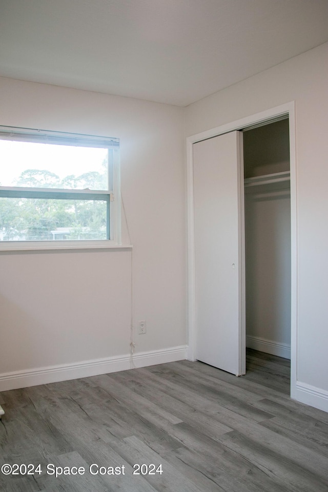 unfurnished bedroom featuring light hardwood / wood-style flooring and a closet