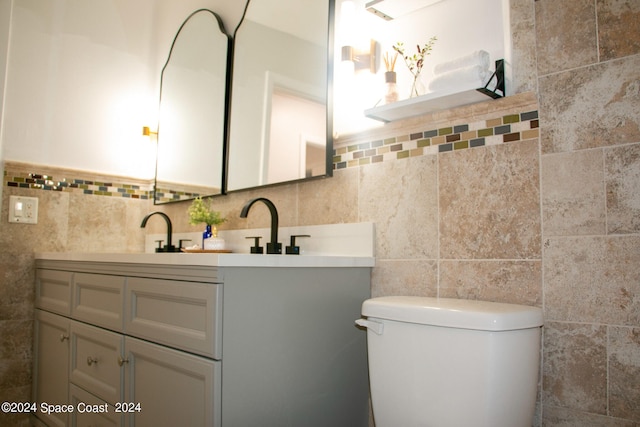 bathroom with tile walls, vanity, and toilet