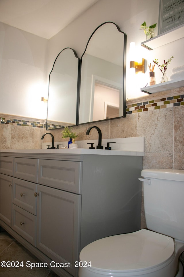 bathroom featuring vanity, tile walls, tile patterned flooring, and toilet