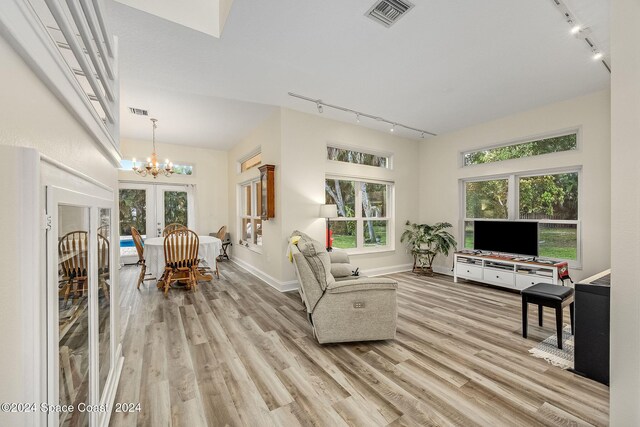 1165 Old Parsonage Dr, Merritt Island, FL 32952 - living area with track lighting, light wood-style floors, french doors, a chandelier, and baseboards