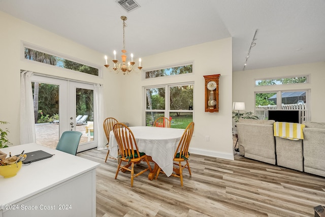 dining room with plenty of natural light, french doors, and light hardwood / wood-style floors