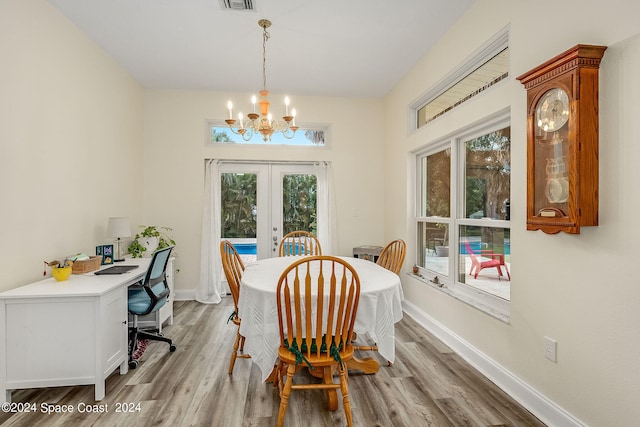 dining area featuring french doors, plenty of natural light, light hardwood / wood-style floors, and a chandelier