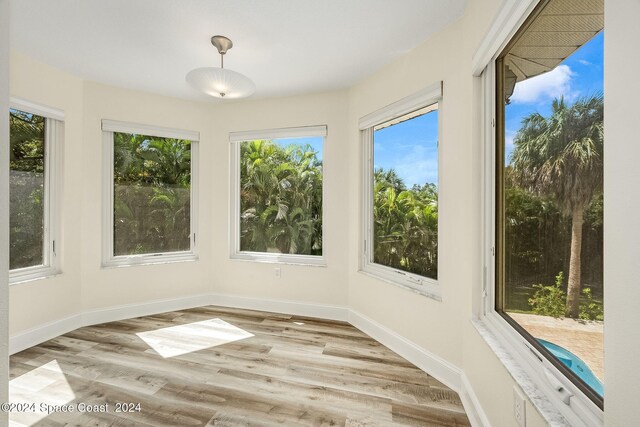 1165 Old Parsonage Dr, Merritt Island, FL 32952 - unfurnished sunroom featuring plenty of natural light, wood finished floors, and baseboards