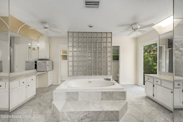 full bathroom with vanity, a textured ceiling, shower with separate bathtub, ceiling fan with notable chandelier, and toilet