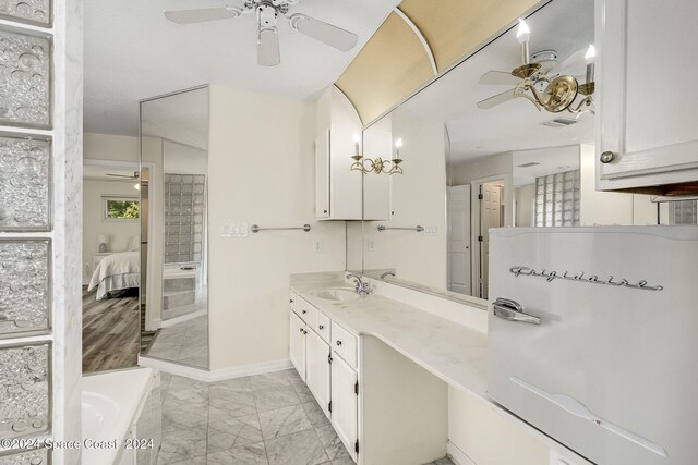 1165 Old Parsonage Dr, Merritt Island, FL 32952 - ensuite bathroom with ceiling fan, marble look tile flooring, vanity, a tub, and baseboards