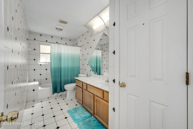 full bathroom with shower / bath combination with curtain, vanity, toilet, a textured ceiling, and tile patterned flooring