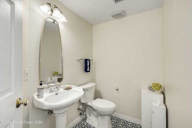 bathroom with a textured ceiling and toilet