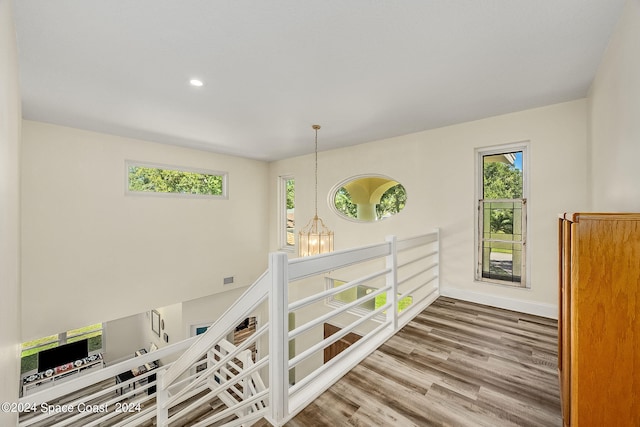 hallway featuring hardwood / wood-style floors and a chandelier