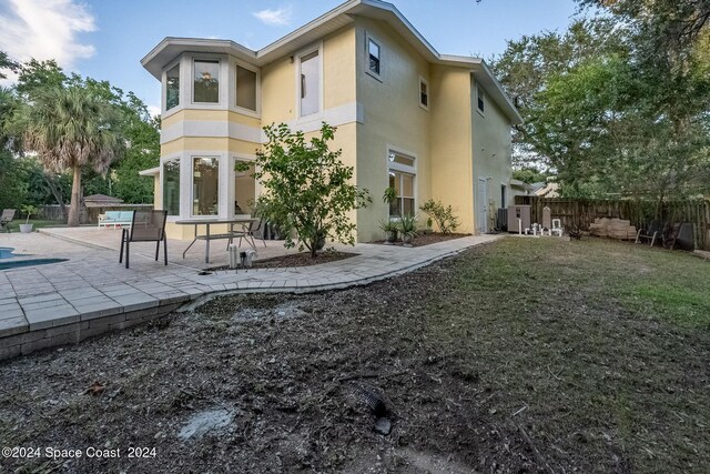 1165 Old Parsonage Dr, Merritt Island, FL 32952 - back of house featuring stucco siding, a patio area, a fenced backyard, and central AC
