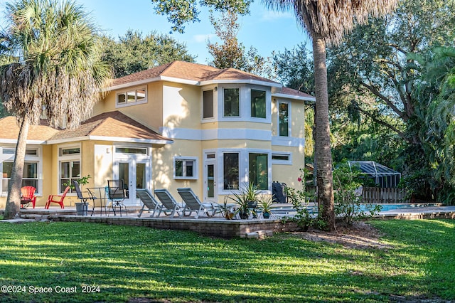 back of house with a pool, a patio, and a lawn