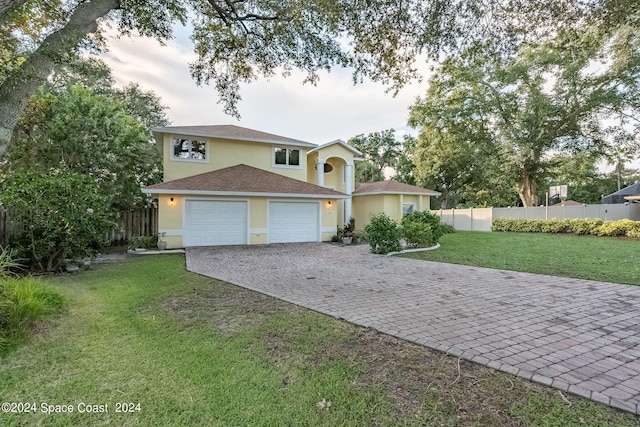 view of property with a garage and a front yard