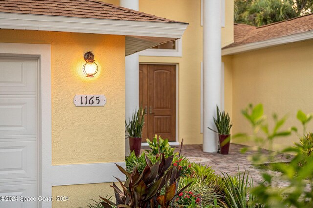1165 Old Parsonage Dr, Merritt Island, FL 32952 - view of exterior entry with a shingled roof and stucco siding