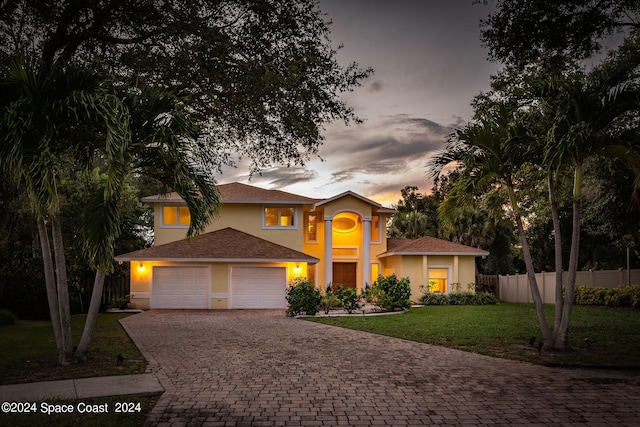 mediterranean / spanish-style home featuring a lawn and a garage