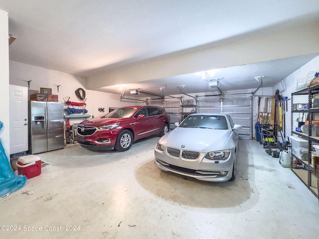 garage featuring a garage door opener and stainless steel fridge