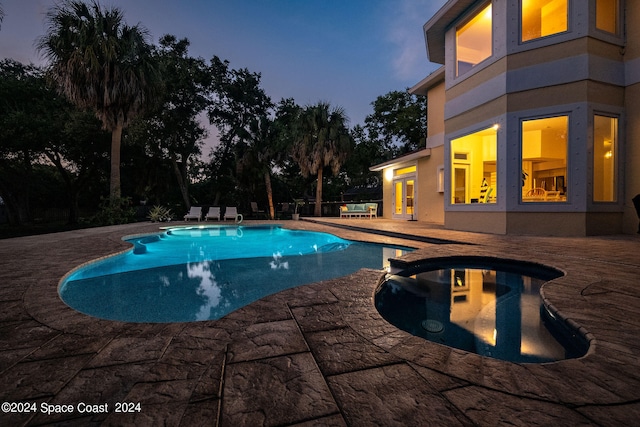 pool at dusk featuring a patio area