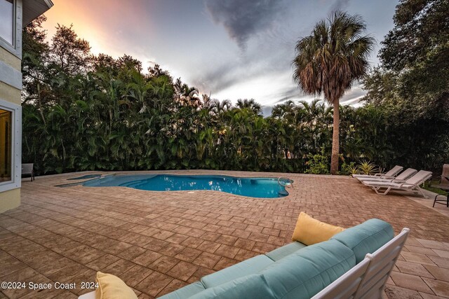 1165 Old Parsonage Dr, Merritt Island, FL 32952 - pool at dusk featuring a patio, outdoor lounge area, and an outdoor pool