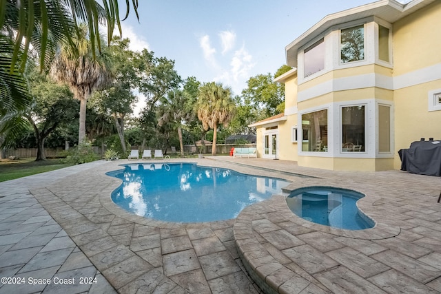 view of pool featuring an in ground hot tub and a patio