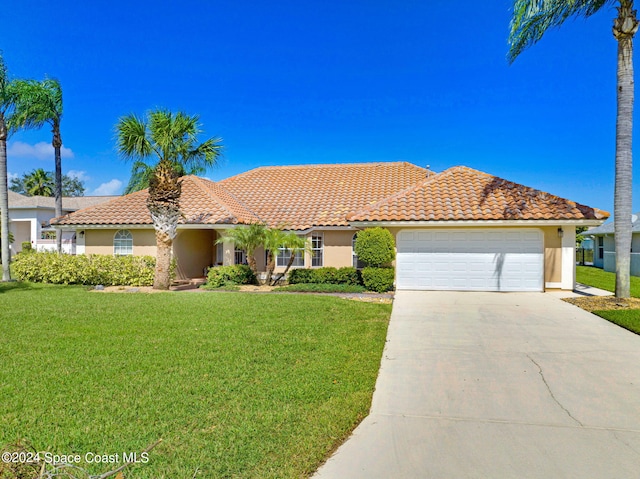 view of front of home with a front yard and a garage