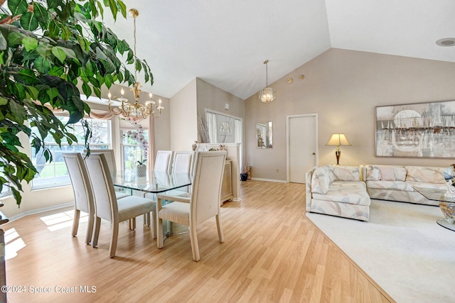 dining space featuring high vaulted ceiling, a notable chandelier, and light wood-type flooring