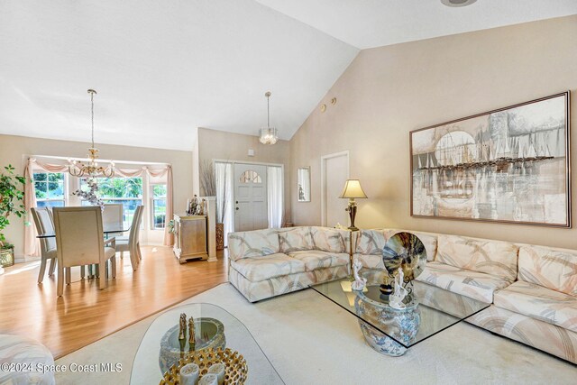 living room with a chandelier, high vaulted ceiling, and wood-type flooring