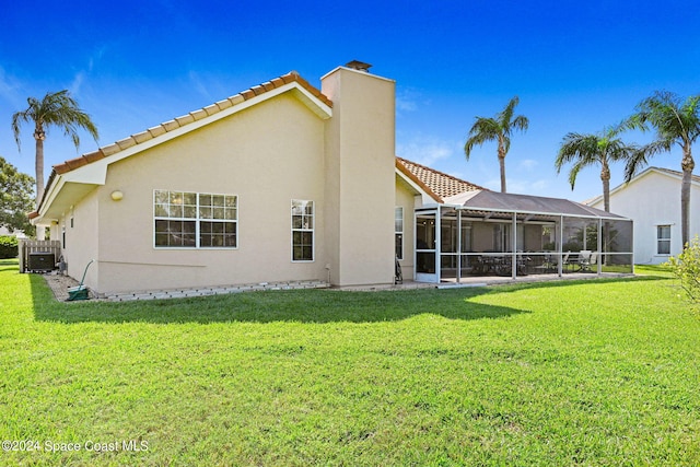 back of property with a yard, central AC, and a lanai