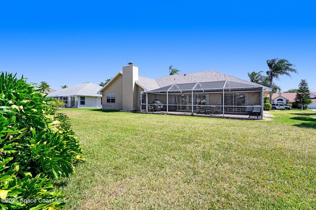 818 Spanish Wells Dr, Melbourne, FL 32940 - rear view of property featuring glass enclosure, a lawn, a chimney, and stucco siding