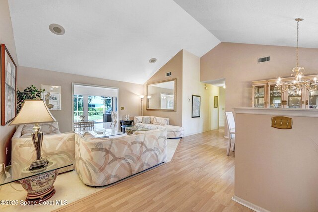 818 Spanish Wells Dr, Melbourne, FL 32940 - living room with wood finished floors, visible vents, high vaulted ceiling, and a notable chandelier