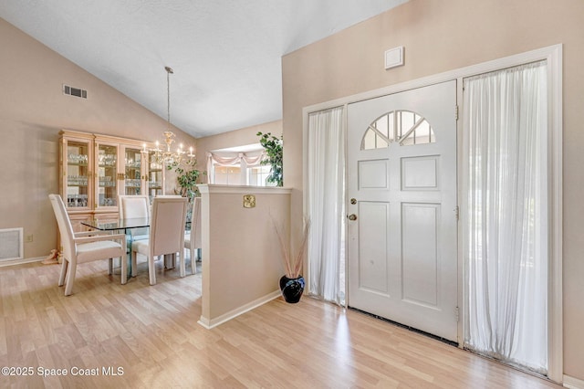 818 Spanish Wells Dr, Melbourne, FL 32940 - foyer entrance featuring high vaulted ceiling, a notable chandelier, wood finished floors, and visible vents
