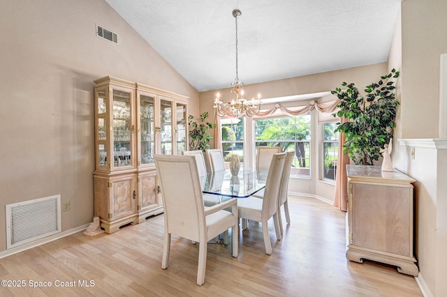 818 Spanish Wells Dr, Melbourne, FL 32940 - dining room featuring light wood-style flooring, visible vents, an inviting chandelier, and vaulted ceiling