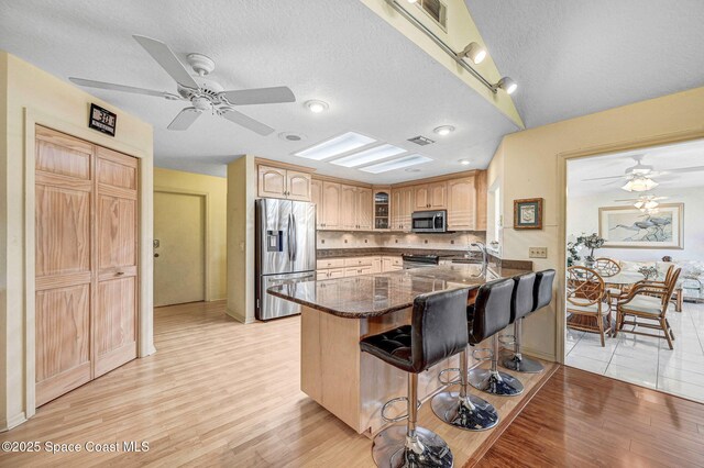 818 Spanish Wells Dr, Melbourne, FL 32940 - kitchen featuring light wood finished floors, a sink, glass insert cabinets, ceiling fan, and appliances with stainless steel finishes