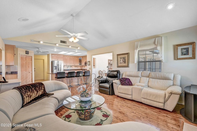 818 Spanish Wells Dr, Melbourne, FL 32940 - living area with light wood finished floors, a ceiling fan, visible vents, and vaulted ceiling