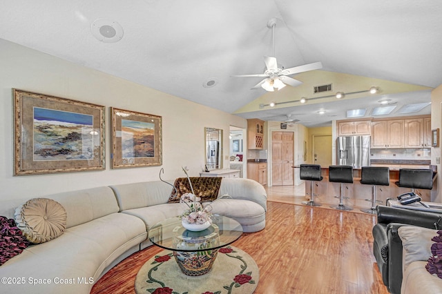 818 Spanish Wells Dr, Melbourne, FL 32940 - living room with ceiling fan, lofted ceiling, light wood-style floors, and visible vents