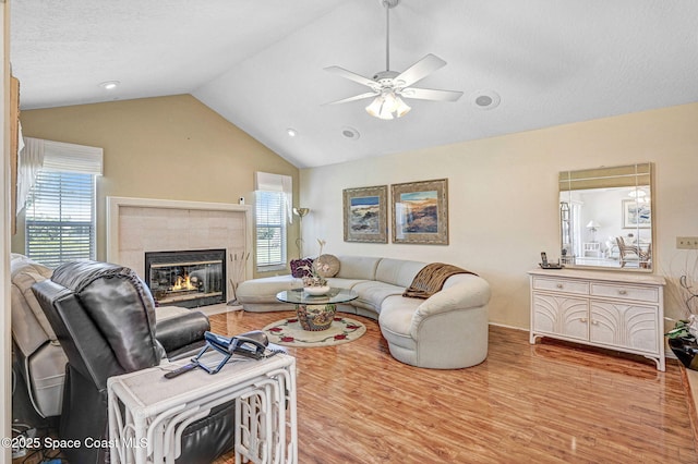 818 Spanish Wells Dr, Melbourne, FL 32940 - living area featuring vaulted ceiling, a tiled fireplace, wood finished floors, and ceiling fan