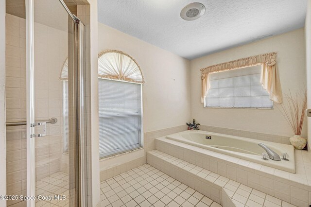 818 Spanish Wells Dr, Melbourne, FL 32940 - bathroom featuring a textured ceiling, a shower stall, a garden tub, and a wealth of natural light