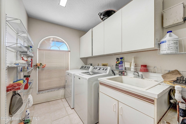 818 Spanish Wells Dr, Melbourne, FL 32940 - clothes washing area featuring a sink, a textured ceiling, light tile patterned floors, cabinet space, and independent washer and dryer
